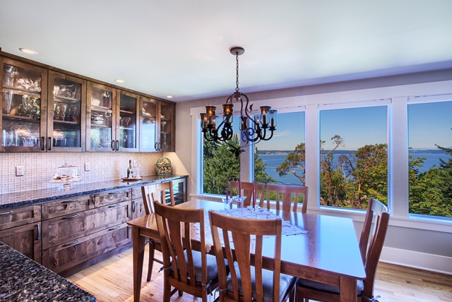 Eat-in kitchen - large rustic u-shaped light wood floor eat-in kitchen idea in Seattle with a double-bowl sink, recessed-panel cabinets, distressed cabinets, quartz countertops, beige backsplash, ceramic backsplash, stainless steel appliances and an island