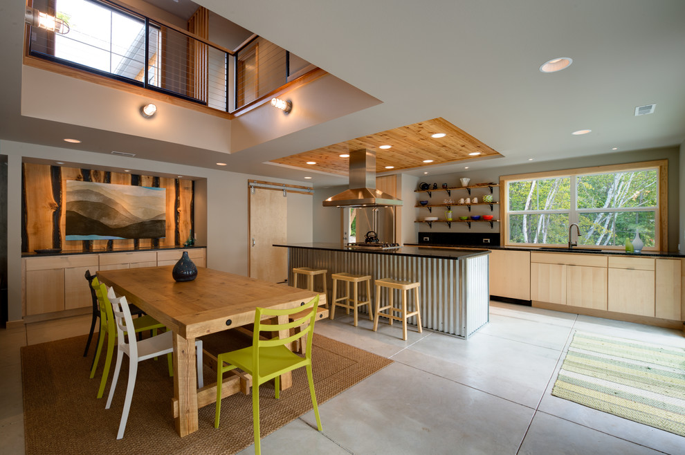 This is an example of a beach style galley eat-in kitchen in Other with flat-panel cabinets and light wood cabinets.