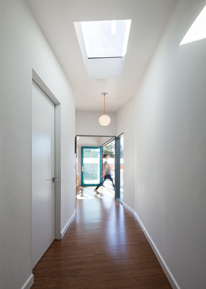 Inspiration for a midcentury hallway in Los Angeles with white walls and medium hardwood floors.
