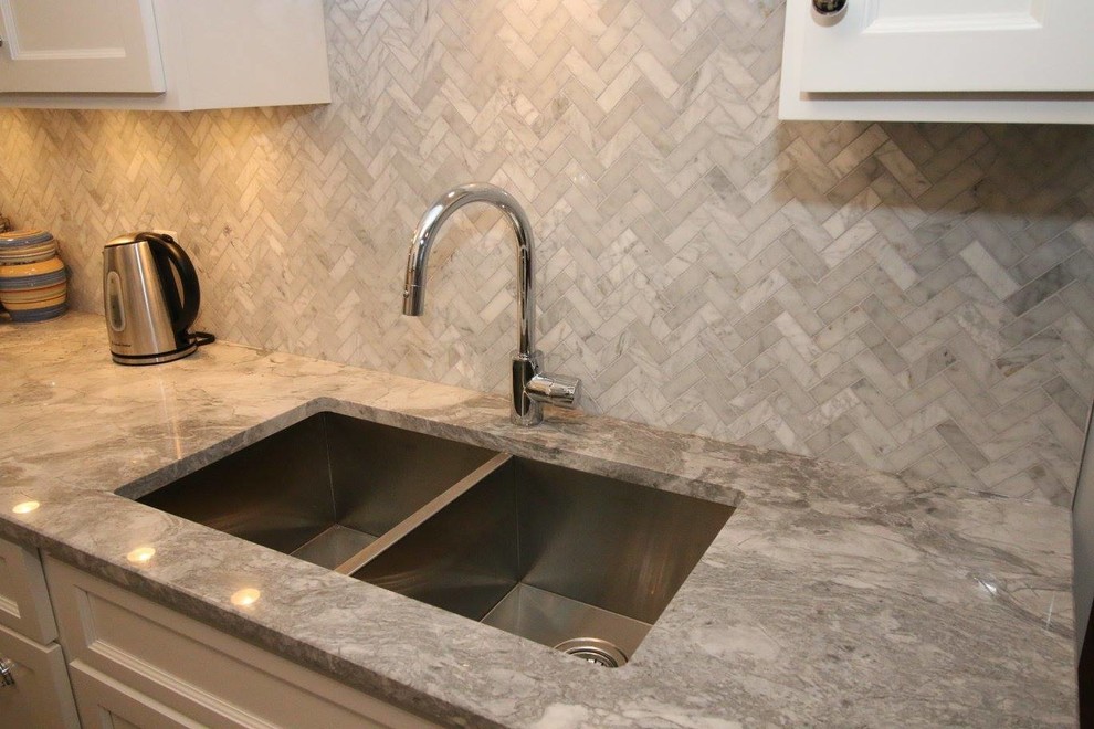 Kitchen - transitional kitchen idea with raised-panel cabinets, white cabinets, marble countertops, gray backsplash, matchstick tile backsplash and stainless steel appliances