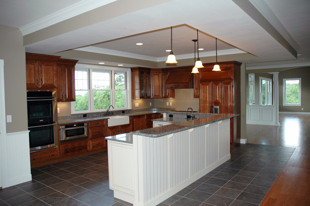 Photo of a large country l-shaped eat-in kitchen in Manchester with a farmhouse sink, raised-panel cabinets, granite benchtops, stainless steel appliances, ceramic floors and with island.