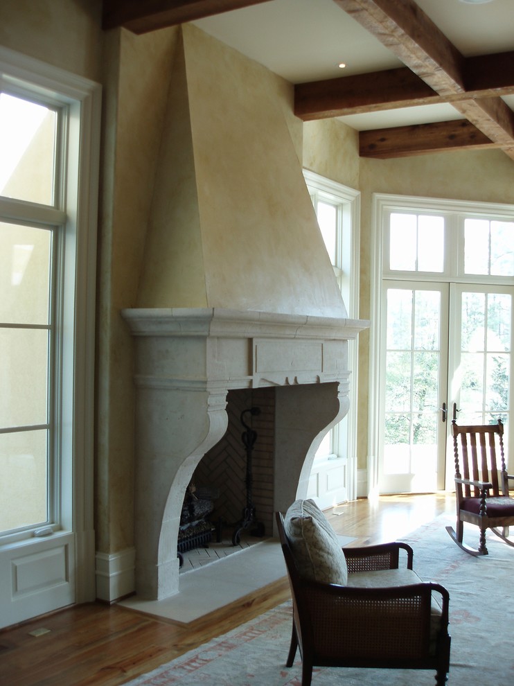 This is an example of a mediterranean living room in Raleigh with dark hardwood floors and a concrete fireplace surround.