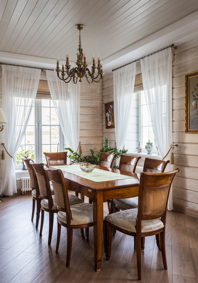 Aménagement d'une grande salle à manger ouverte sur le salon classique avec un mur beige, un sol en carrelage de porcelaine, un poêle à bois, un manteau de cheminée en métal et un sol beige.