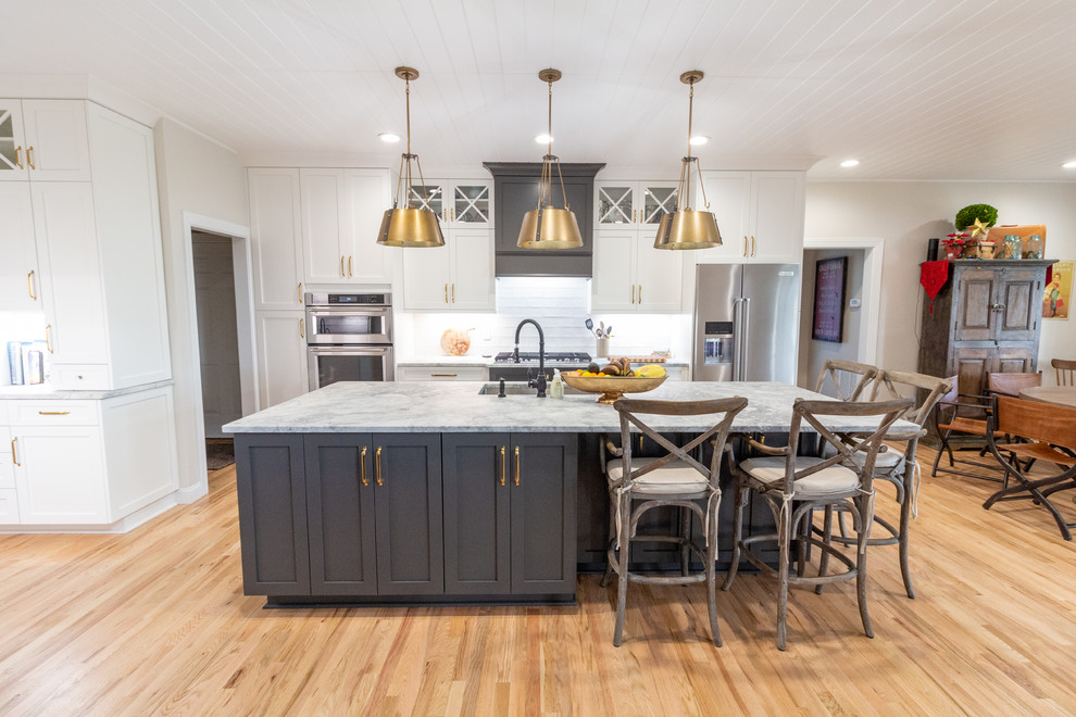 Large l-shaped eat-in kitchen photo with shaker cabinets, white cabinets, granite countertops, an island and white countertops