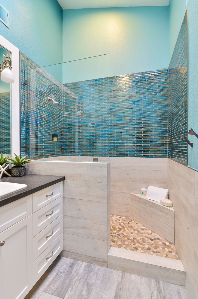 Photo of a mid-sized beach style master bathroom in San Diego with shaker cabinets, white cabinets, engineered quartz benchtops, an open shower, beige tile and porcelain tile.