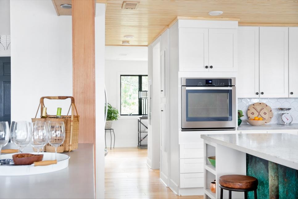 Inspiration for a large beach style l-shaped open plan kitchen in Orlando with a farmhouse sink, shaker cabinets, yellow cabinets, terrazzo benchtops, white splashback, ceramic splashback, stainless steel appliances, bamboo floors and multiple islands.