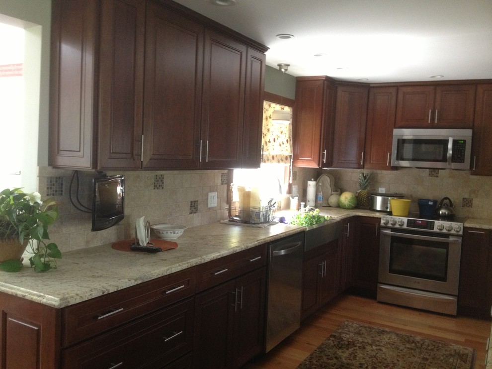 Eat-in kitchen - mid-sized eclectic l-shaped medium tone wood floor eat-in kitchen idea in Bridgeport with an undermount sink, shaker cabinets, dark wood cabinets, granite countertops, beige backsplash, ceramic backsplash, stainless steel appliances and an island