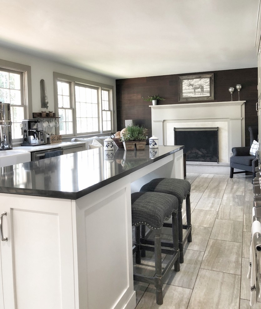 Design ideas for a mid-sized country galley open plan kitchen in Other with a farmhouse sink, shaker cabinets, white cabinets, quartz benchtops, stainless steel appliances, porcelain floors, with island and beige floor.