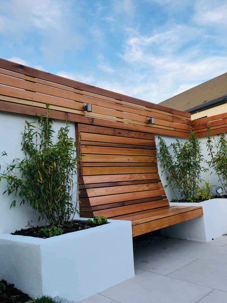 Diseño de jardín de estilo zen de tamaño medio en verano en patio trasero con macetero elevado, exposición parcial al sol, adoquines de piedra natural y con madera
