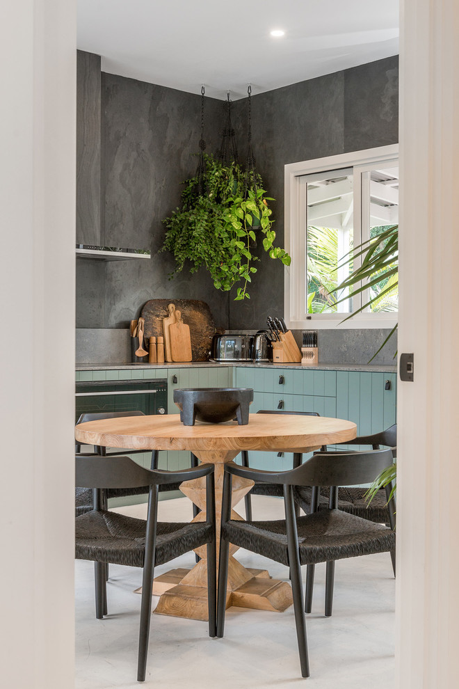 Mid-sized contemporary l-shaped eat-in kitchen in Sydney with an undermount sink, flat-panel cabinets, green cabinets, quartz benchtops, grey splashback, slate splashback, stainless steel appliances, painted wood floors, white floor and grey benchtop.