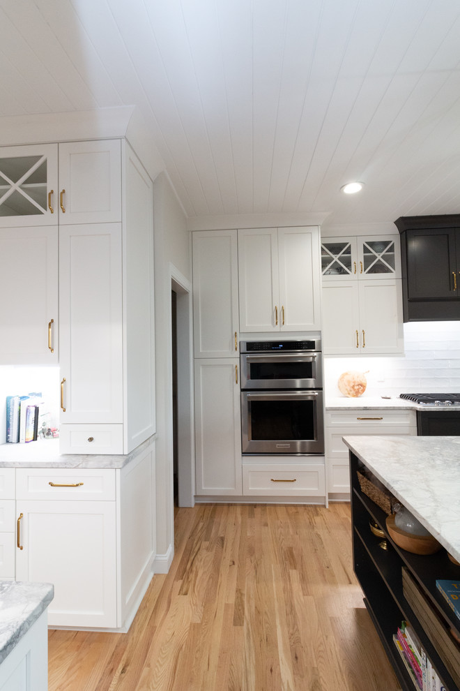 Eat-in kitchen - large l-shaped eat-in kitchen idea with shaker cabinets, white cabinets, granite countertops, an island and white countertops