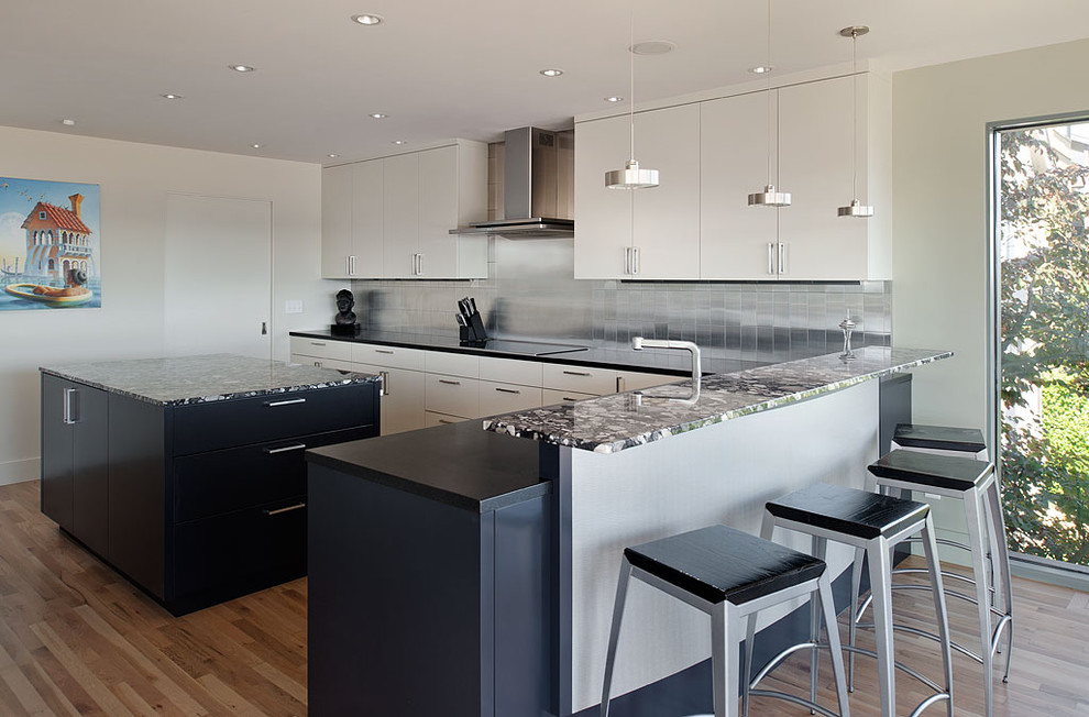 This is an example of a contemporary kitchen in Seattle with metal splashback.