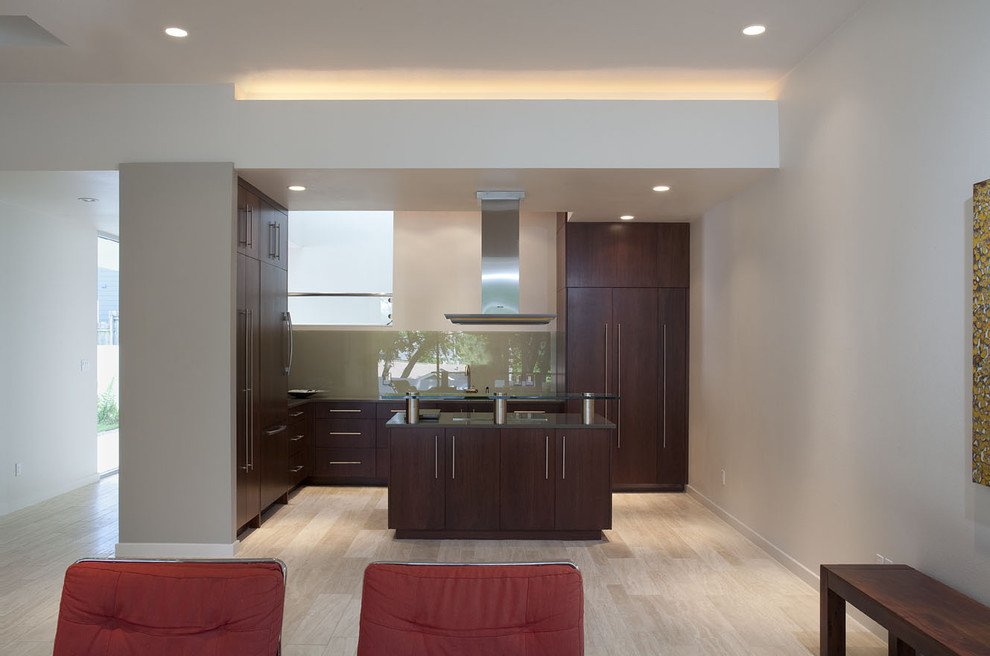 Modern open plan kitchen in Austin with glass benchtops, flat-panel cabinets, dark wood cabinets and glass sheet splashback.
