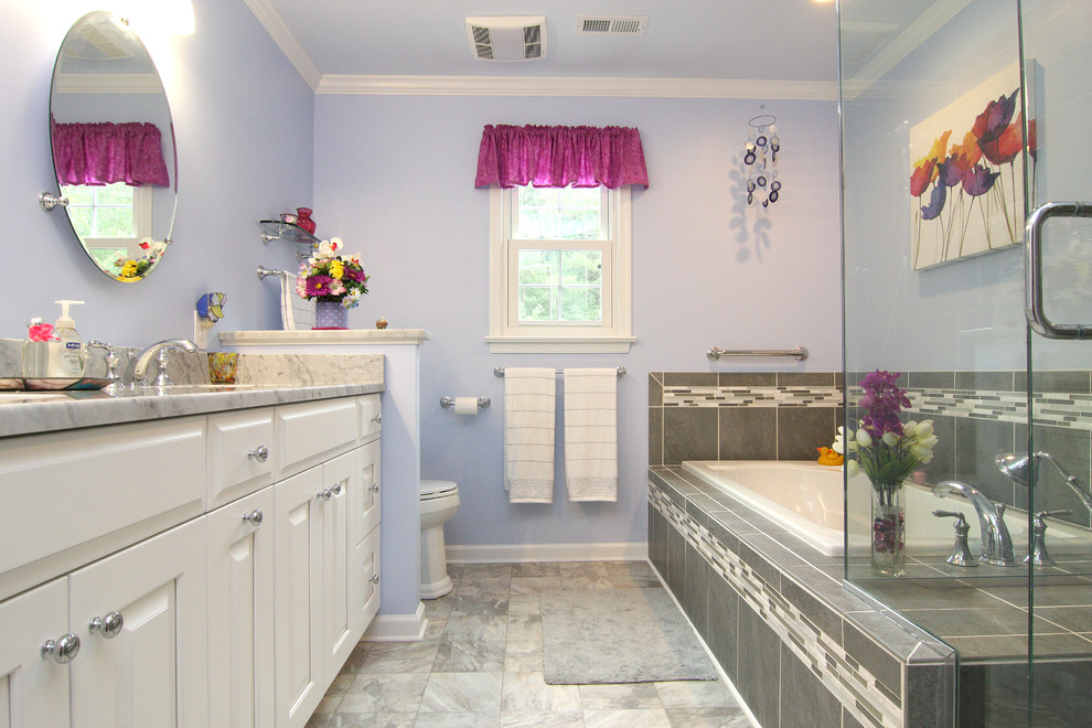 Drop-in bathtub - mid-sized transitional master gray tile and porcelain tile linoleum floor drop-in bathtub idea with an undermount sink, raised-panel cabinets, white cabinets, marble countertops, a two-piece toilet and purple walls