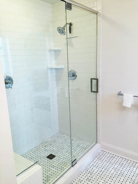 This is an example of a mid-sized country master bathroom in Milwaukee with an alcove shower, white tile, porcelain tile, white walls and marble floors.
