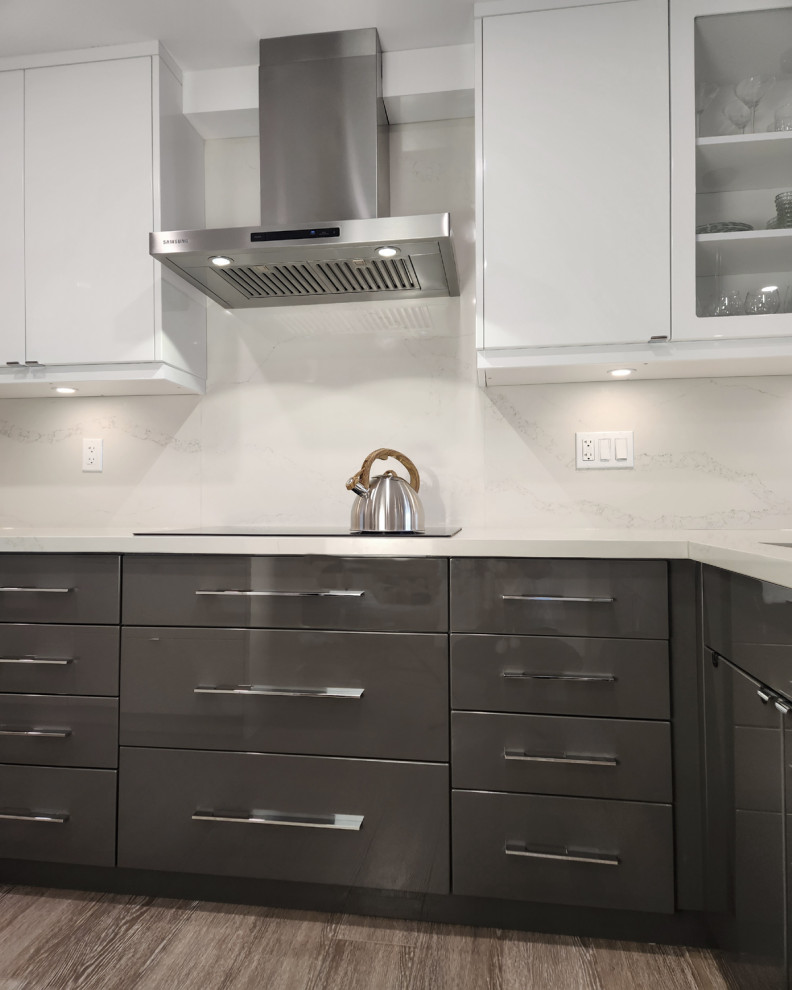 This is an example of a mid-sized contemporary l-shaped eat-in kitchen in Toronto with an undermount sink, flat-panel cabinets, yellow cabinets, quartz benchtops, white splashback, engineered quartz splashback, stainless steel appliances, medium hardwood floors, a peninsula, brown floor and white benchtop.