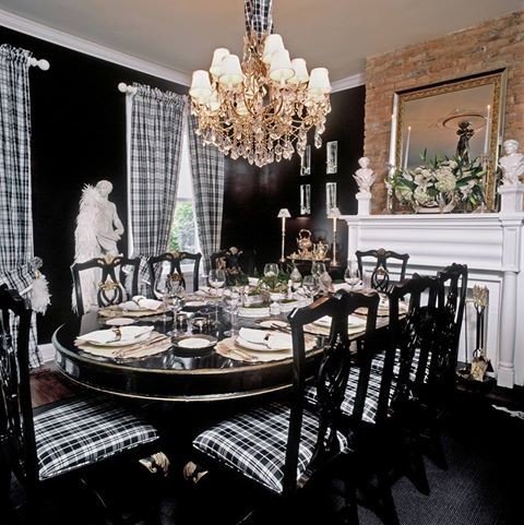 This is an example of a mid-sized traditional separate dining room in Las Vegas with black walls, dark hardwood floors and a standard fireplace.