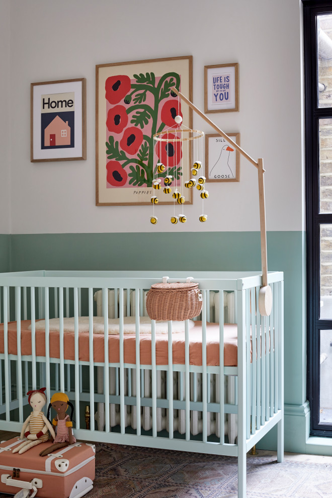 Inspiration for a medium sized contemporary nursery for girls in London with green walls.