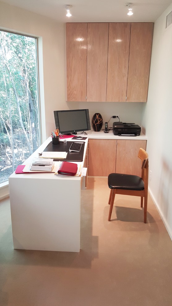 Photo of a mid-sized modern study room in Austin with white walls and a built-in desk.
