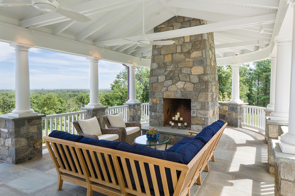 Photo of a large traditional side yard patio in New York with natural stone pavers, a gazebo/cabana and a fire feature.