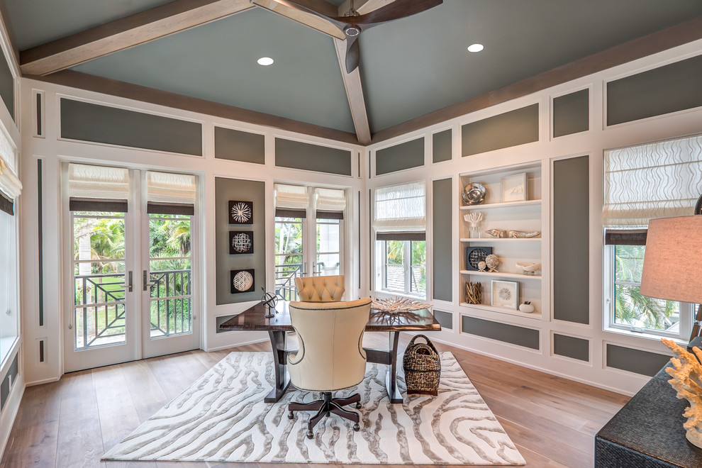 This is an example of a mid-sized transitional study room in Other with grey walls, light hardwood floors and a freestanding desk.