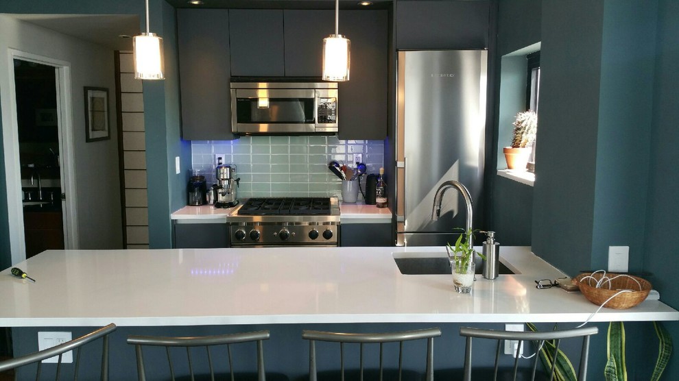 Design ideas for a small contemporary galley eat-in kitchen in New York with an undermount sink, flat-panel cabinets, grey cabinets, quartz benchtops, green splashback, glass tile splashback, stainless steel appliances, porcelain floors, with island and grey floor.
