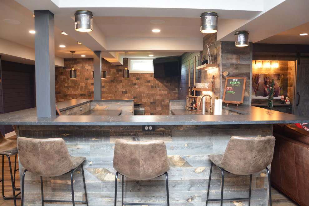 Esempio di un grande angolo bar stile rurale con lavello sottopiano, top in saponaria, paraspruzzi in legno e parquet chiaro