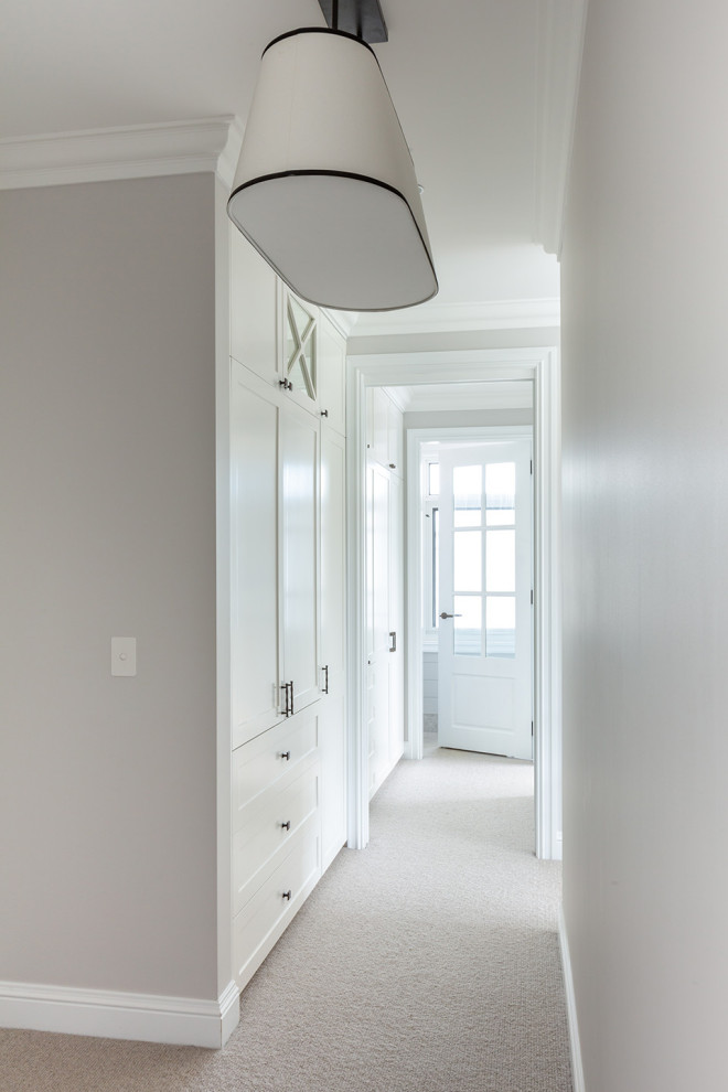 Large nautical gender neutral built-in wardrobe in Sydney with shaker cabinets, white cabinets, carpet, beige floors and a drop ceiling.