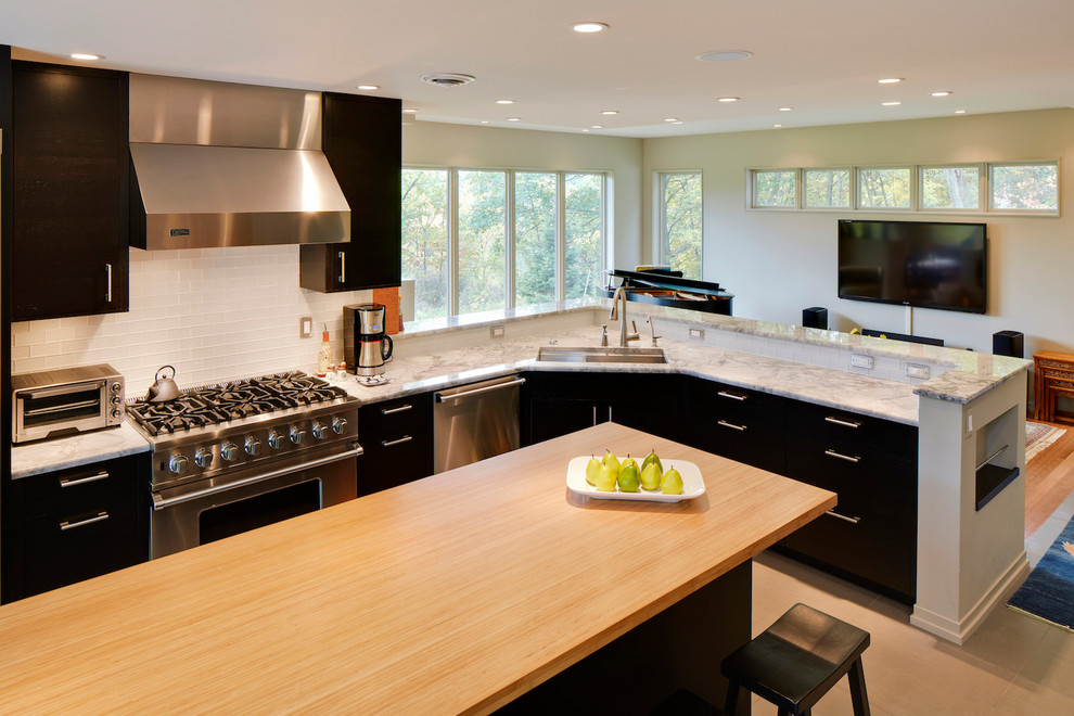 Photo of a mid-sized contemporary l-shaped open plan kitchen in Detroit with flat-panel cabinets, black cabinets, marble benchtops, white splashback, stainless steel appliances, with island, glass tile splashback, an undermount sink, bamboo floors, beige floor and beige benchtop.