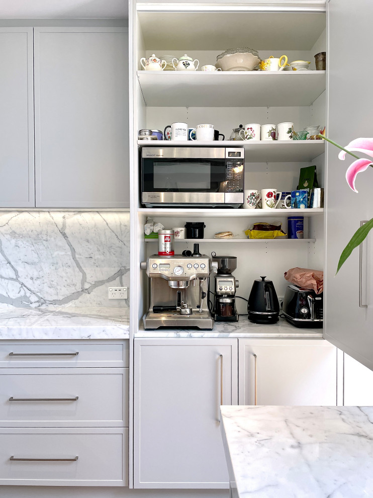 Design ideas for a large l-shaped open plan kitchen in Sydney with an undermount sink, shaker cabinets, grey cabinets, marble benchtops, grey splashback, marble splashback, black appliances, medium hardwood floors, with island, brown floor and grey benchtop.