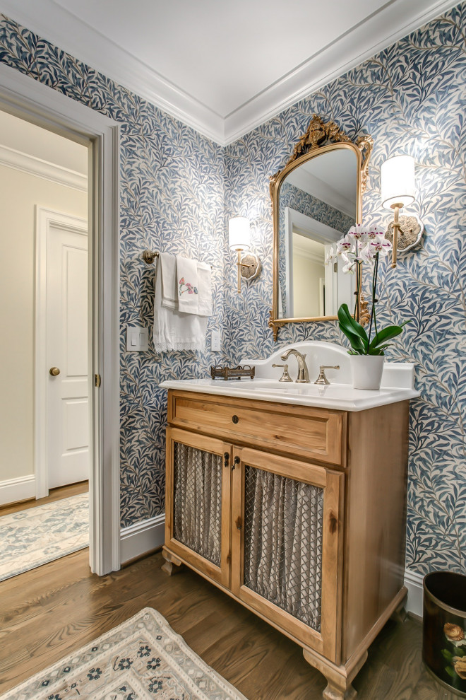 Idées déco pour une salle de bain en bois clair avec un placard sans porte, un mur bleu, un sol en bois brun, un sol marron, meuble simple vasque, meuble-lavabo sur pied et du papier peint.