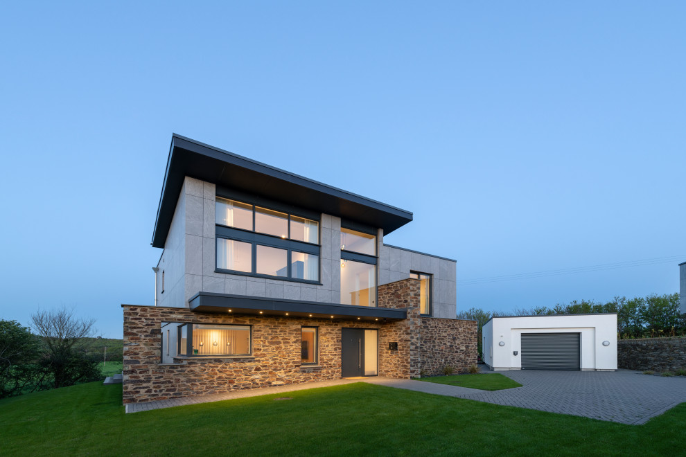 Großes, Zweistöckiges Modernes Einfamilienhaus mit Mix-Fassade, Flachdach, Blechdach und grauem Dach in Cornwall