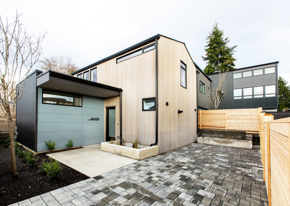 This is an example of a small midcentury two-storey exterior in Seattle with mixed siding, a shingle roof and a grey roof.
