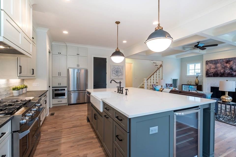 Example of an eclectic kitchen design with a farmhouse sink and solid surface countertops