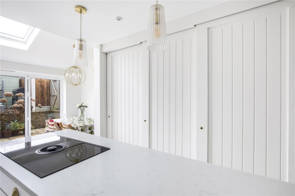 Esempio di una cucina minimal di medie dimensioni con ante in stile shaker, ante bianche, top in superficie solida, pavimento in gres porcellanato, pavimento bianco e top bianco