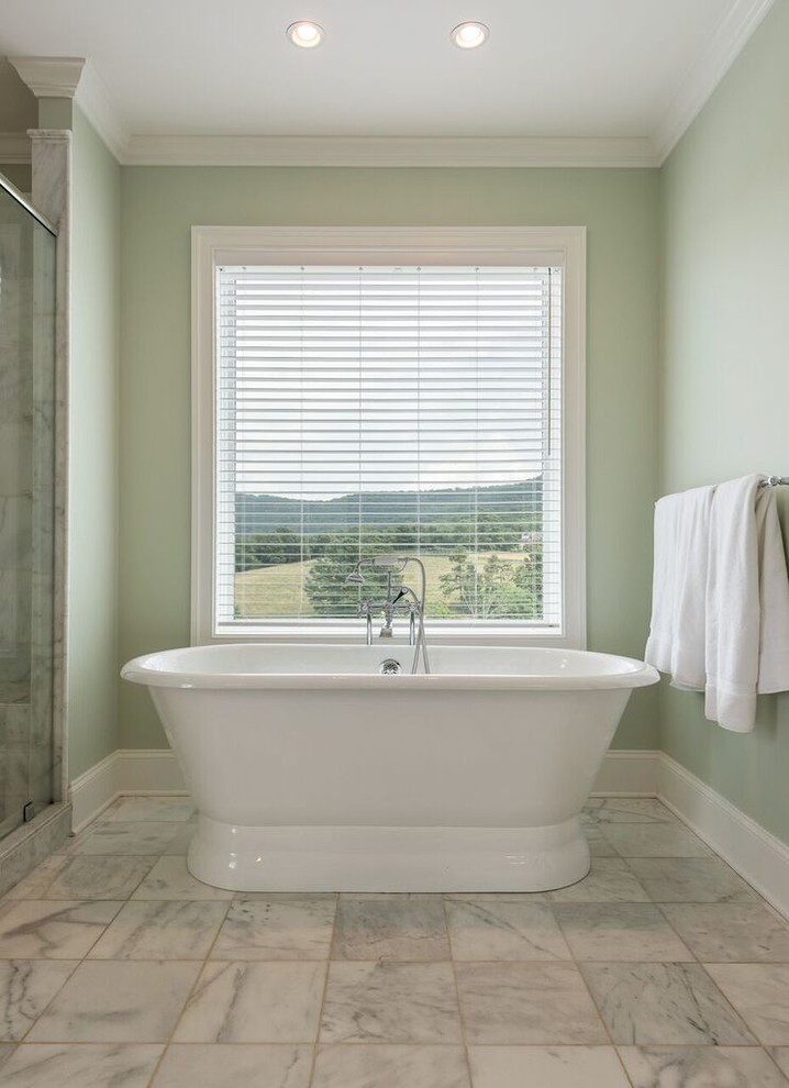 Photo of a large traditional master bathroom in Other with recessed-panel cabinets, white cabinets, a freestanding tub, a corner shower, a two-piece toilet, gray tile, white tile, porcelain tile, green walls, porcelain floors, an undermount sink, marble benchtops, white floor and a hinged shower door.