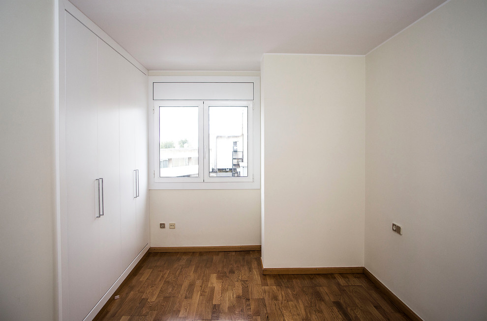 Ejemplo de habitación de invitados tradicional renovada de tamaño medio sin chimenea con paredes beige y suelo de madera oscura