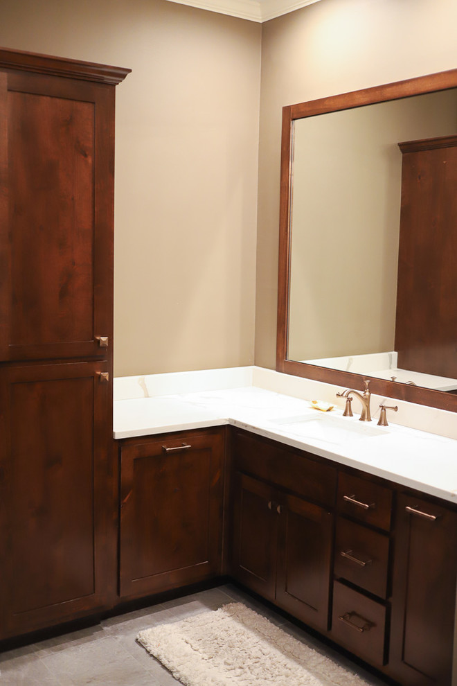 Inspiration for a large transitional master white tile and marble tile porcelain tile and gray floor corner shower remodel with shaker cabinets, dark wood cabinets, an undermount tub, a one-piece toilet, brown walls, an undermount sink, quartz countertops, a hinged shower door and white countertops