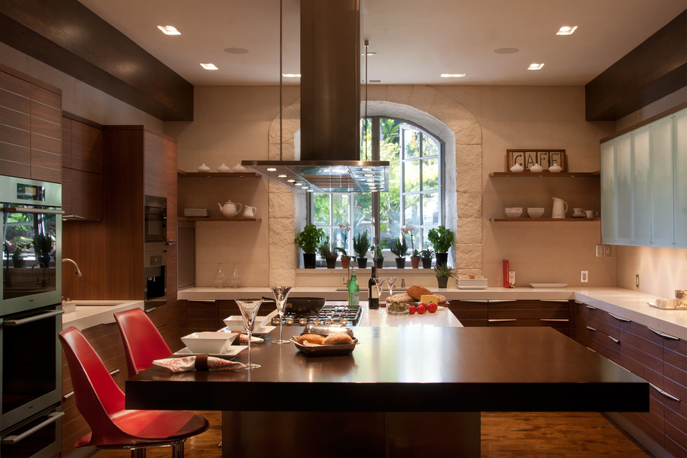 Large contemporary u-shaped eat-in kitchen in Los Angeles with a double-bowl sink, flat-panel cabinets, medium wood cabinets, quartz benchtops, beige splashback, metal splashback, panelled appliances, medium hardwood floors and with island.