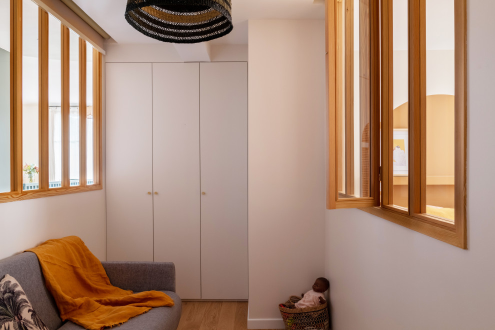 Идея дизайна: маленькая нейтральная комната для малыша в скандинавском стиле с белыми стенами, светлым паркетным полом и коричневым полом для на участке и в саду