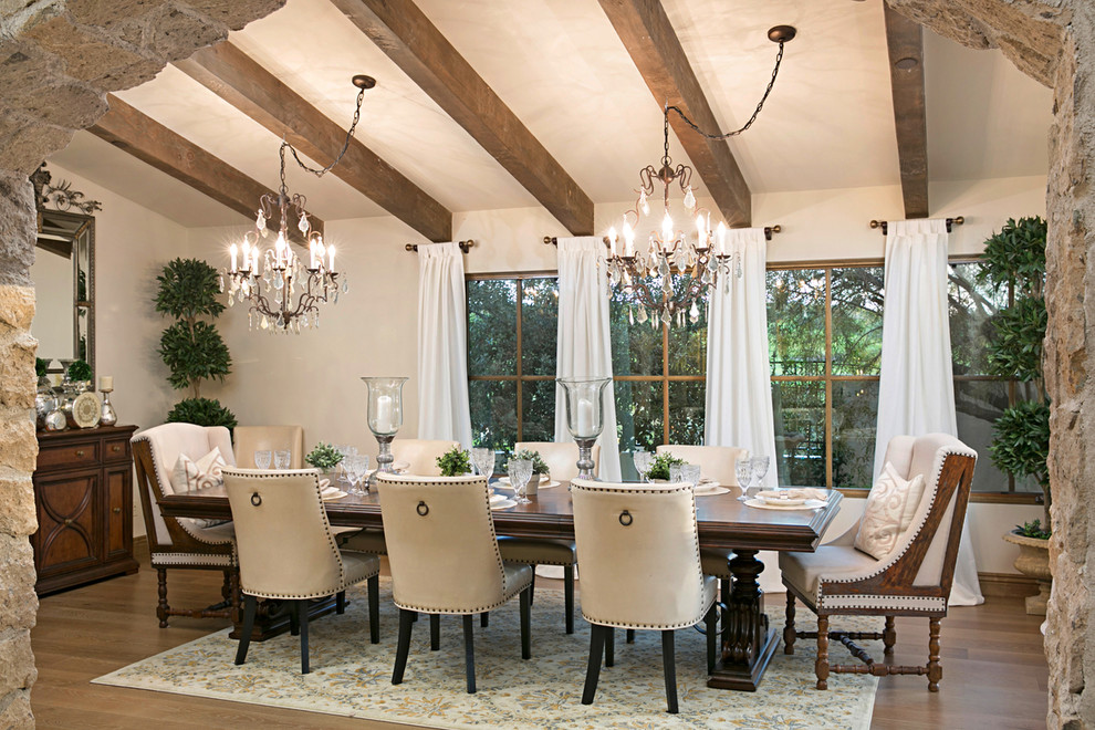 Photo of a mediterranean dining room in San Diego with light hardwood floors, beige floor and white walls.