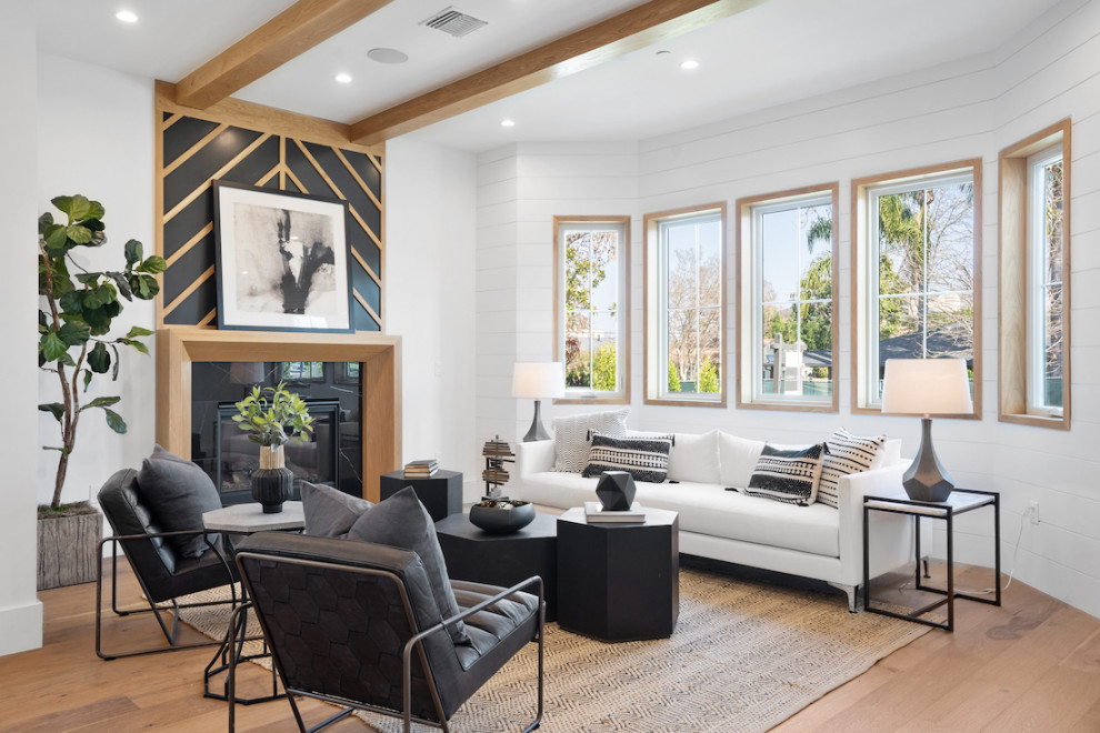 Design ideas for a transitional open concept living room in Los Angeles with white walls, medium hardwood floors, a standard fireplace, a stone fireplace surround, brown floor, exposed beam and planked wall panelling.