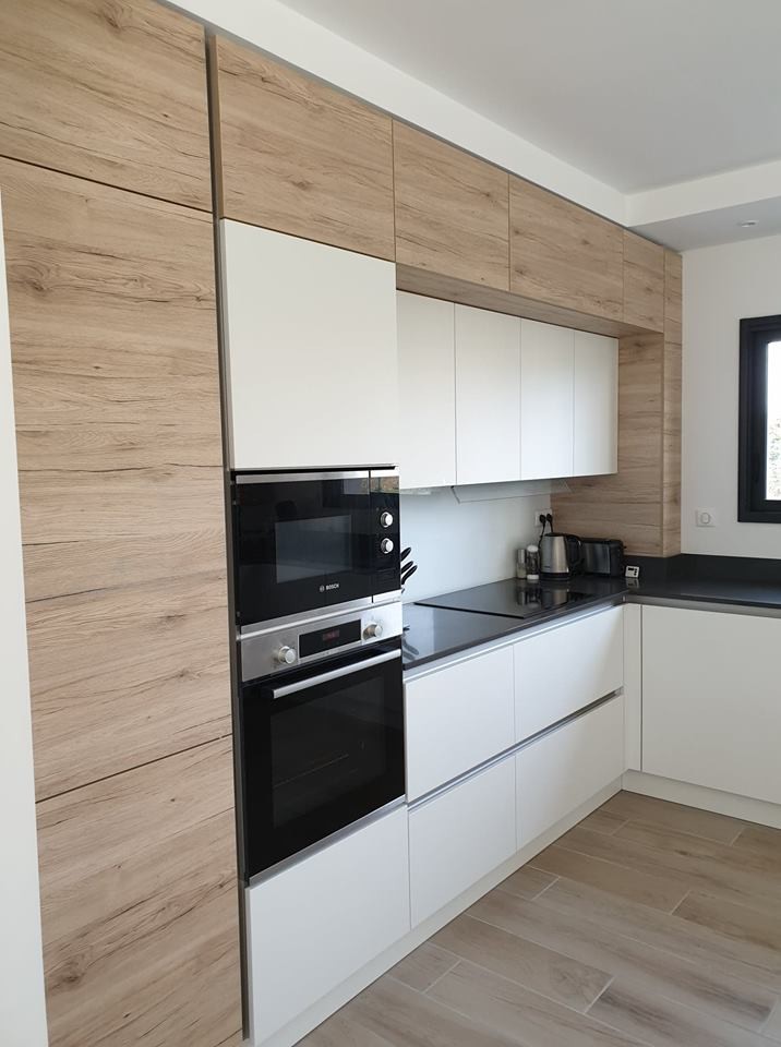 This is an example of a mid-sized modern l-shaped open plan kitchen in Toulouse with quartzite benchtops, white splashback, panelled appliances, with island, grey benchtop, an integrated sink, beaded inset cabinets, stainless steel cabinets, glass tile splashback, light hardwood floors and brown floor.