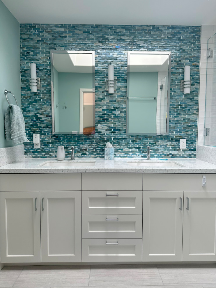Photo of a mid-sized transitional master bathroom in San Francisco with flat-panel cabinets, white cabinets, an alcove shower, a one-piece toilet, blue tile, glass tile, green walls, porcelain floors, an undermount sink, engineered quartz benchtops, grey floor, a hinged shower door, white benchtops, an enclosed toilet, a double vanity and a built-in vanity.