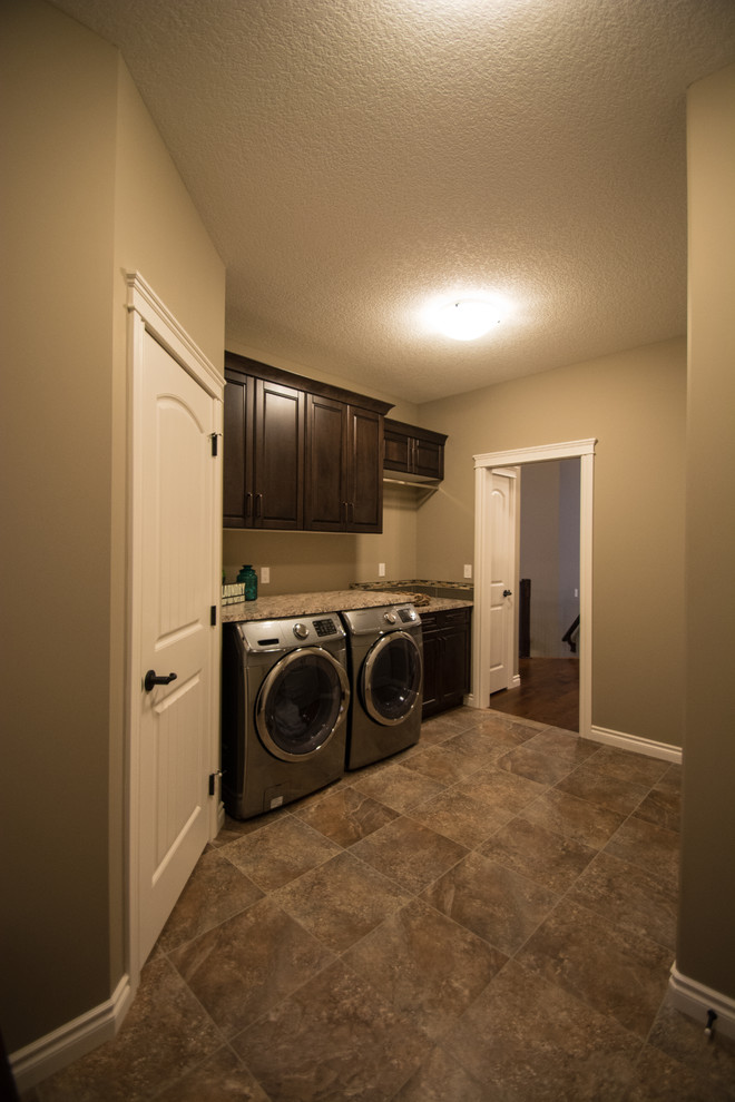 Photo of a mid-sized midcentury single-wall utility room with shaker cabinets, a side-by-side washer and dryer and dark wood cabinets.