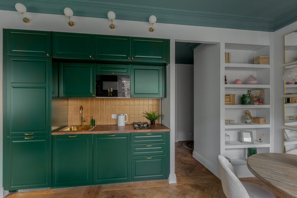 На фото: кухня в стиле неоклассика (современная классика) с зелеными фасадами и желтым фартуком с