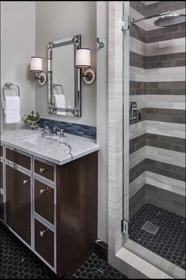 Cette photo montre une salle de bain moderne avec des portes de placard blanches, un carrelage noir et blanc, un mur gris, un lavabo posé et un plan de toilette en marbre.