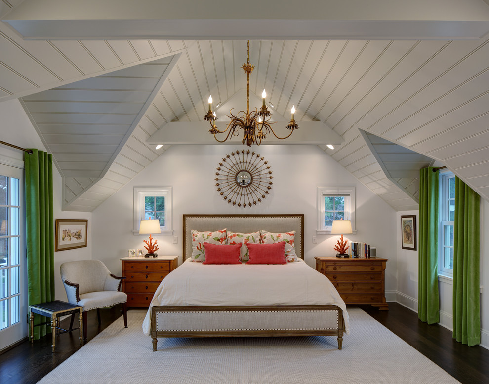 This is an example of a traditional master bedroom in Milwaukee with white walls and dark hardwood floors.