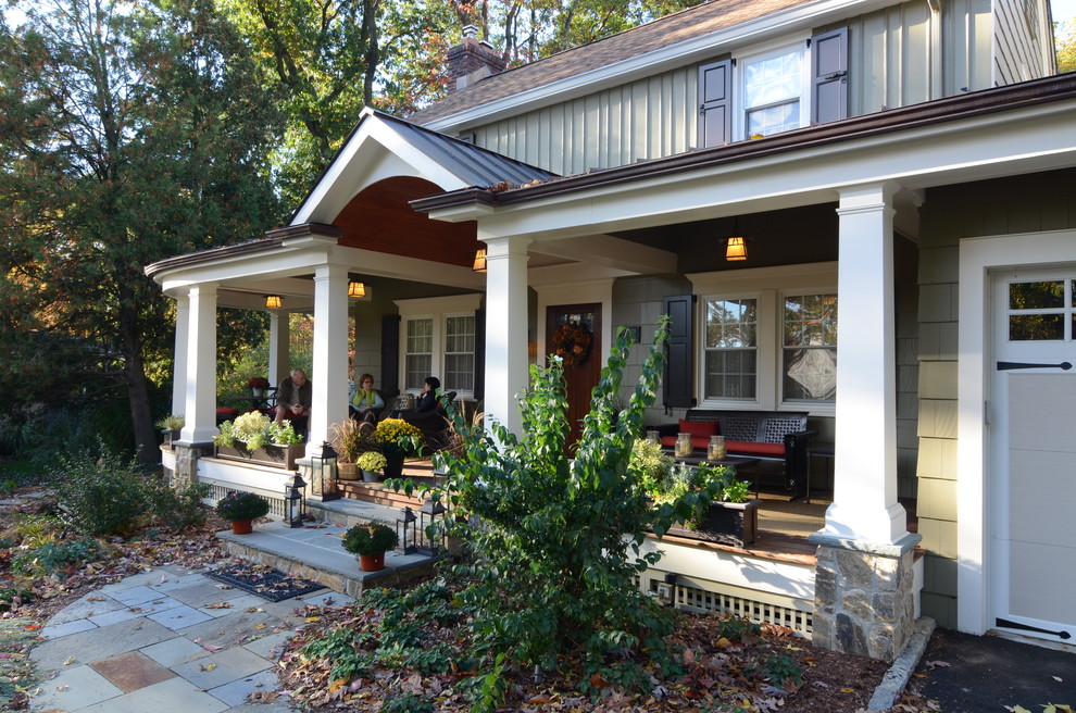 This is an example of a mid-sized traditional front yard verandah in New York with decking and a roof extension.
