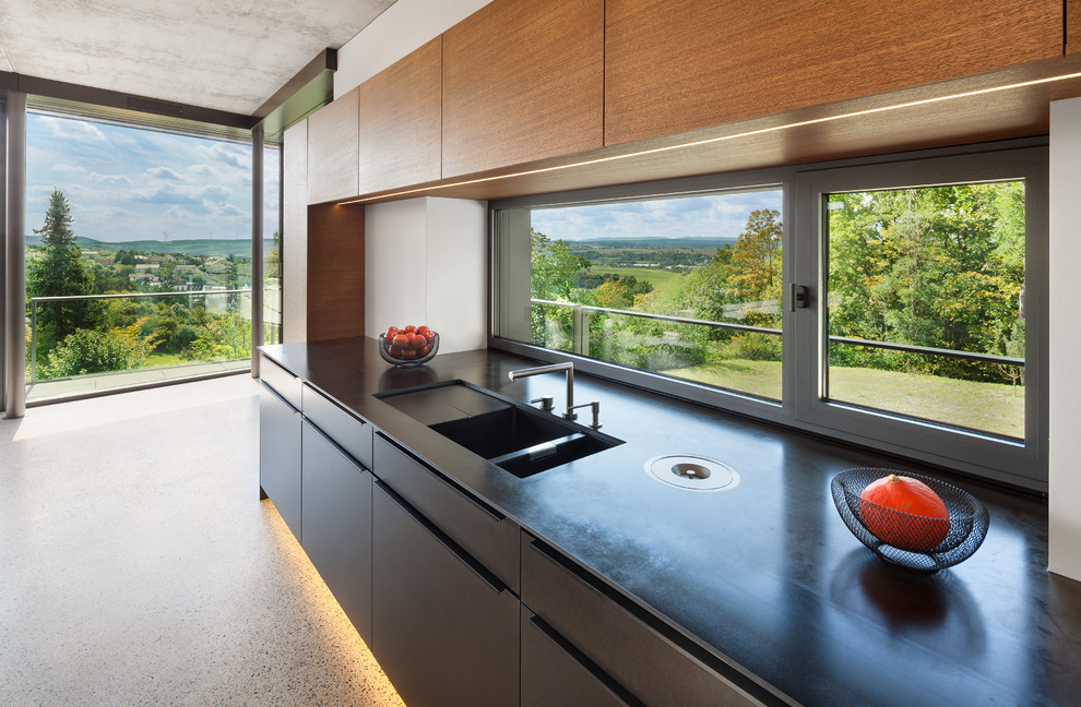 Modern single-wall kitchen in Other with a drop-in sink, flat-panel cabinets, glass sheet splashback, panelled appliances, terrazzo floors and multi-coloured floor.
